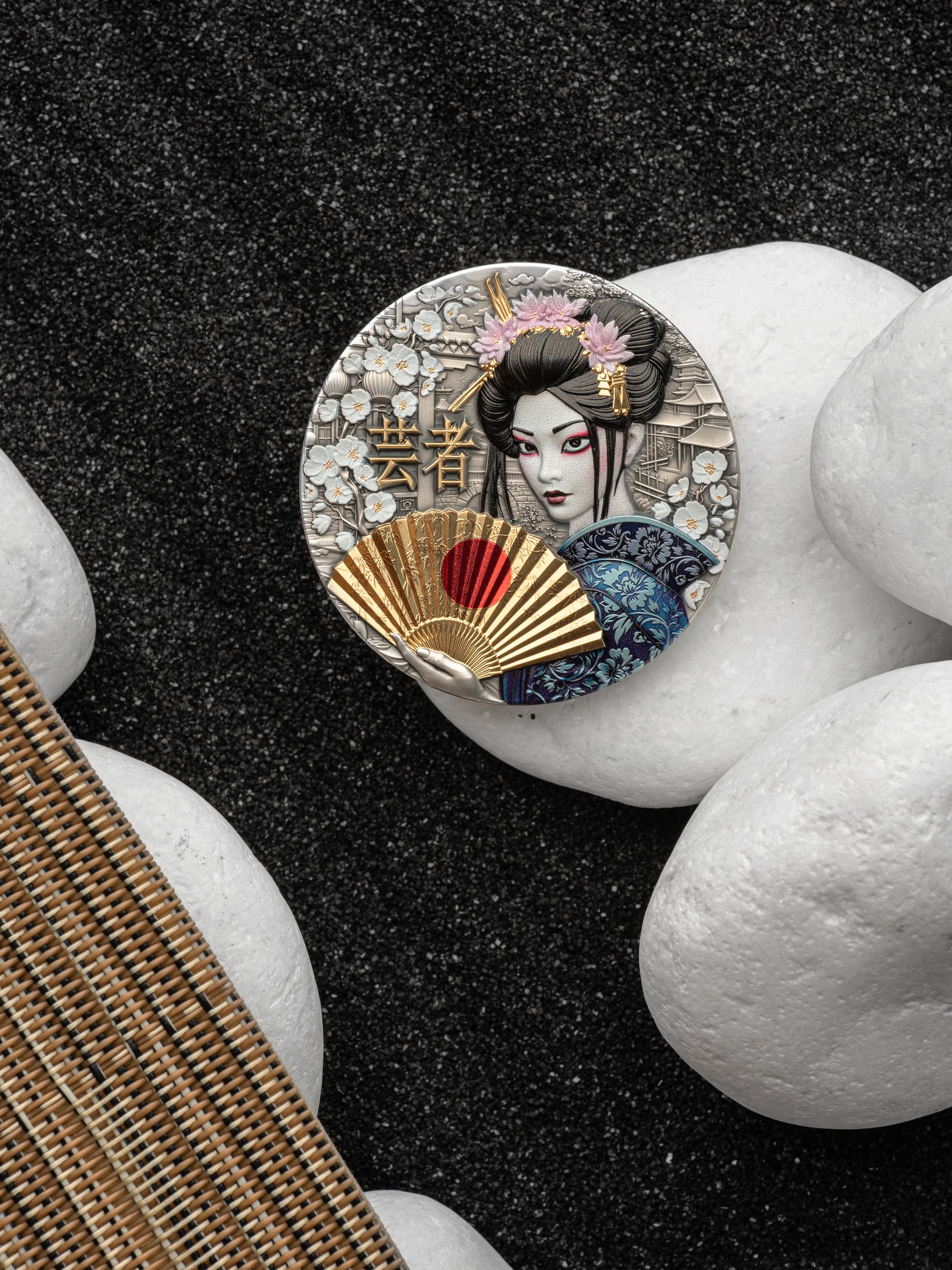 Decorative button with a geisha design on a black and white stone background