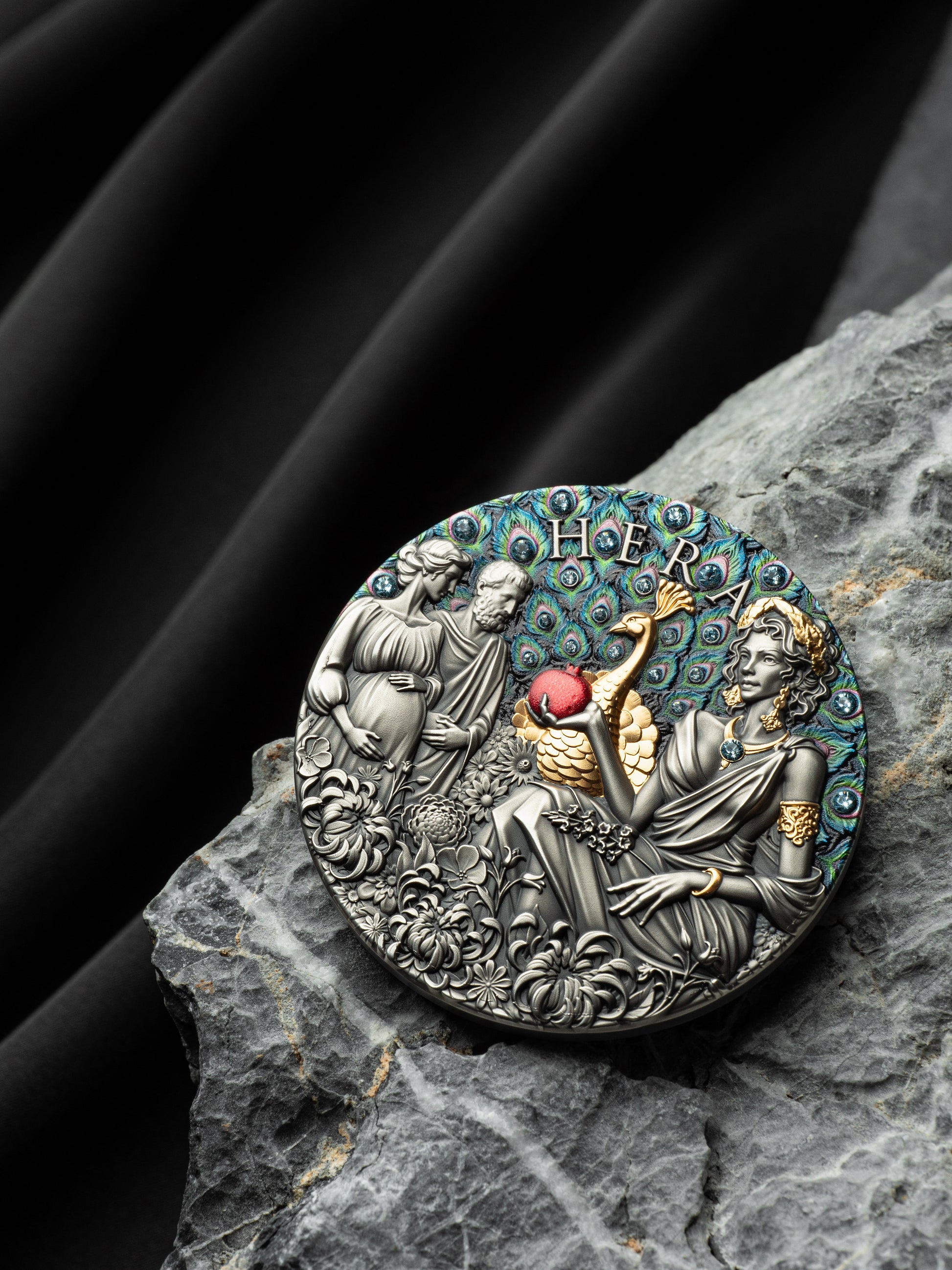 Decorative coin with figures and intricate design on a dark stone surface