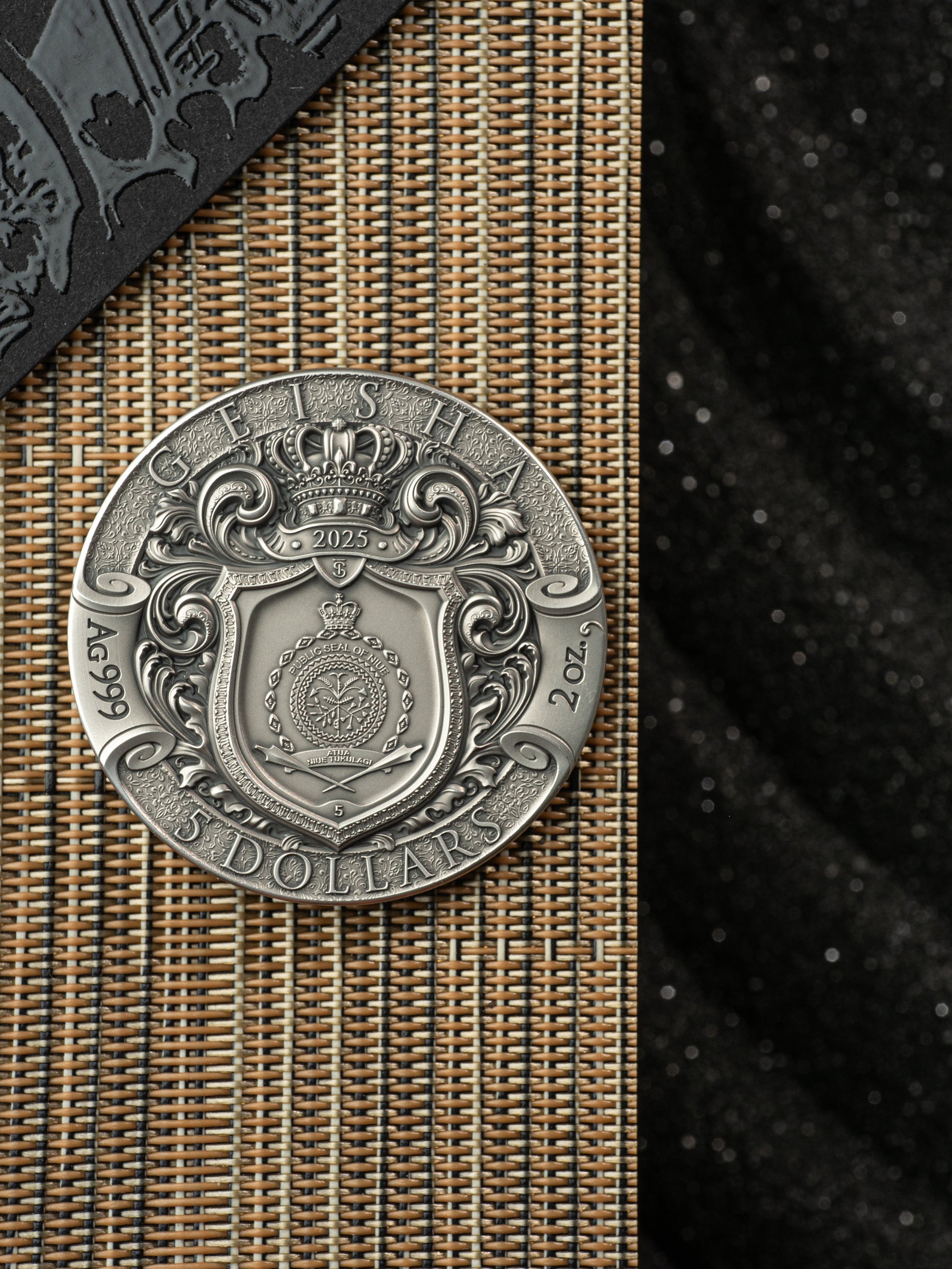 Silver coin with intricate design on a textured surface