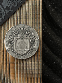Silver coin with intricate design on a textured surface