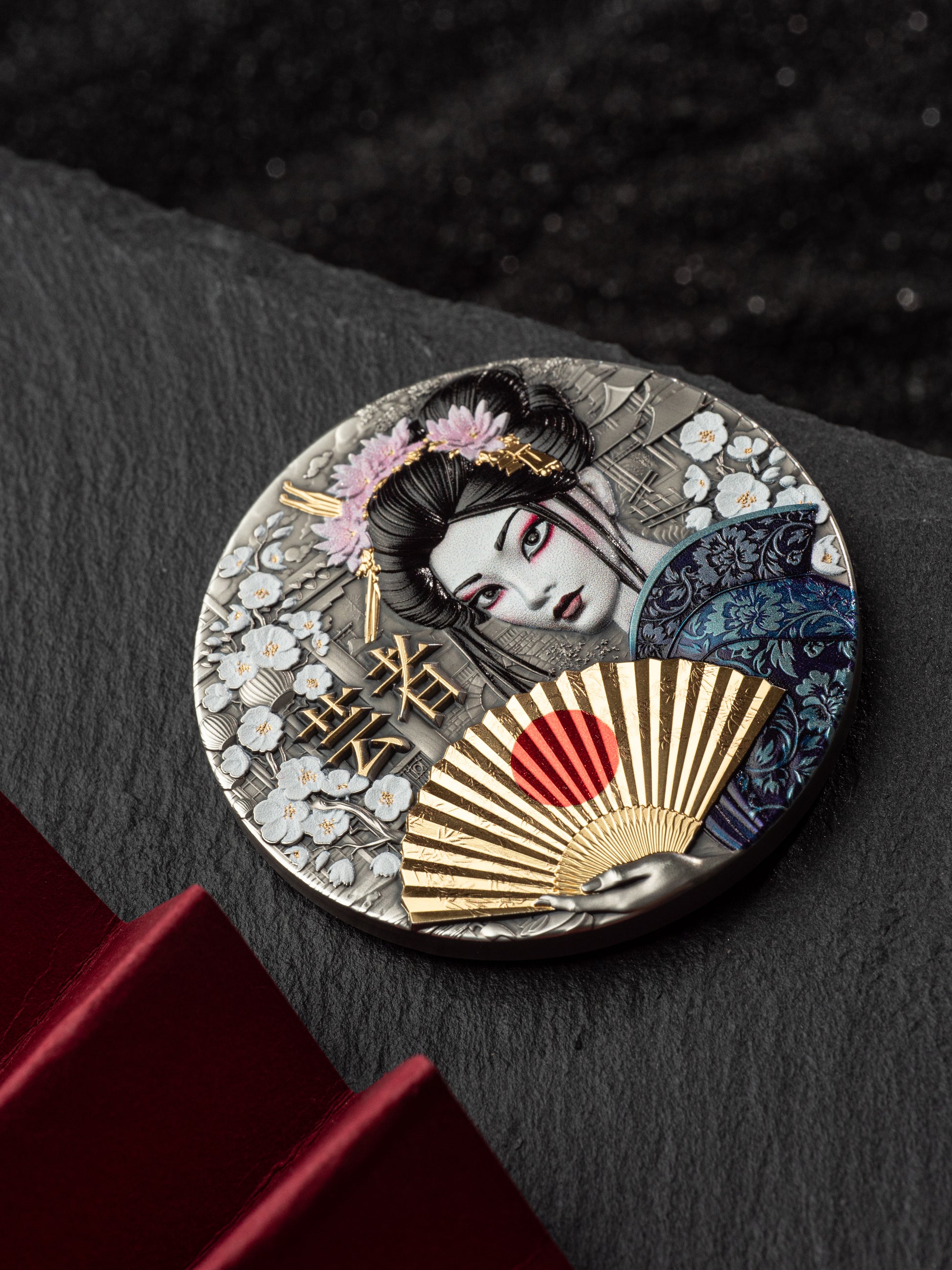 Decorative round object with a geisha design on a dark surface