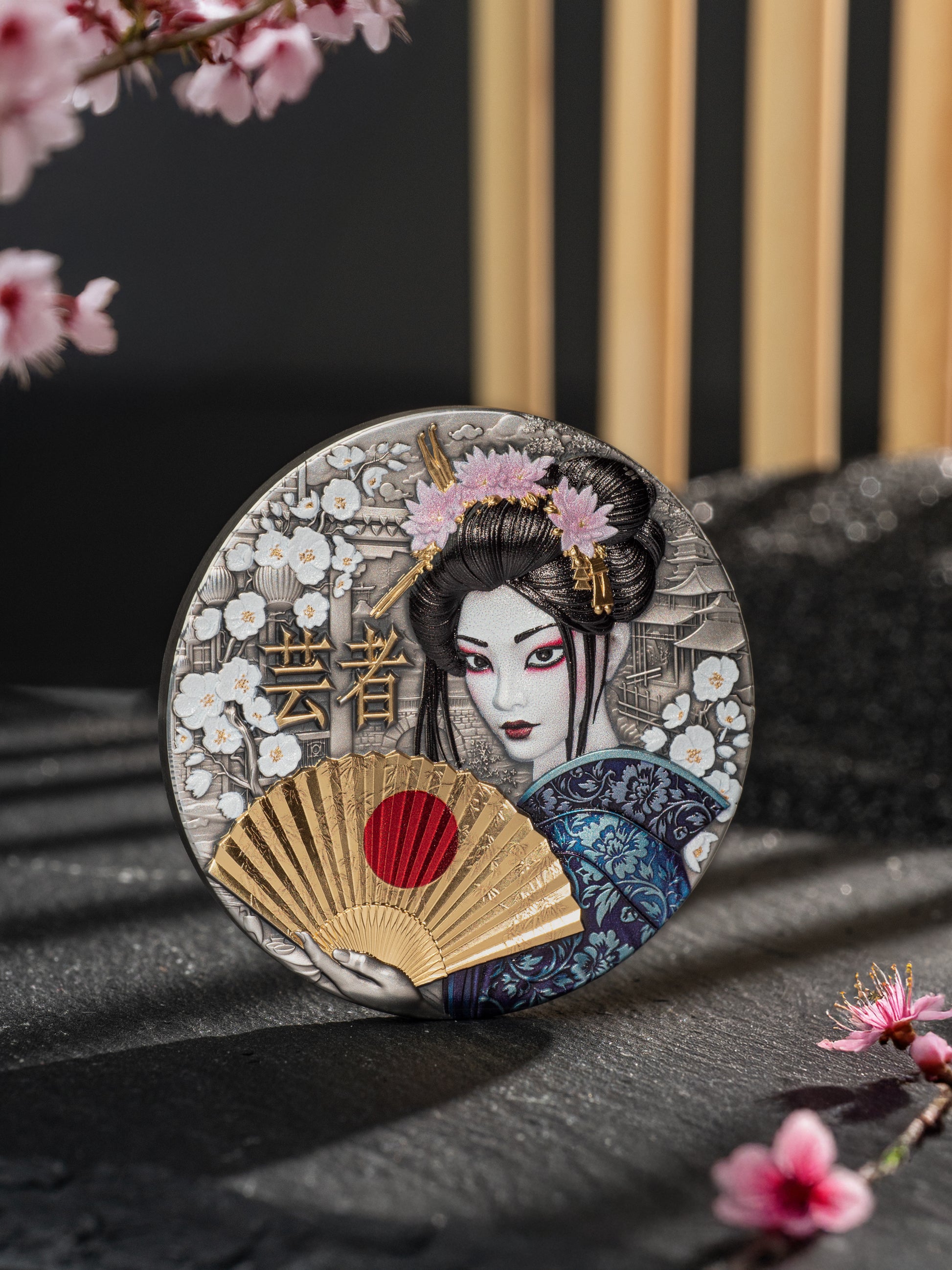 Decorative coaster with a geisha design and cherry blossoms on a dark surface.