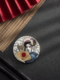 Decorative round emblem with a geisha design on a textured black surface