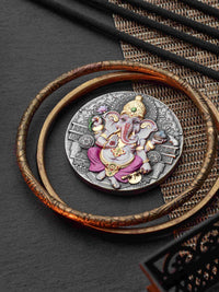 Decorative coin with intricate design on a dark surface