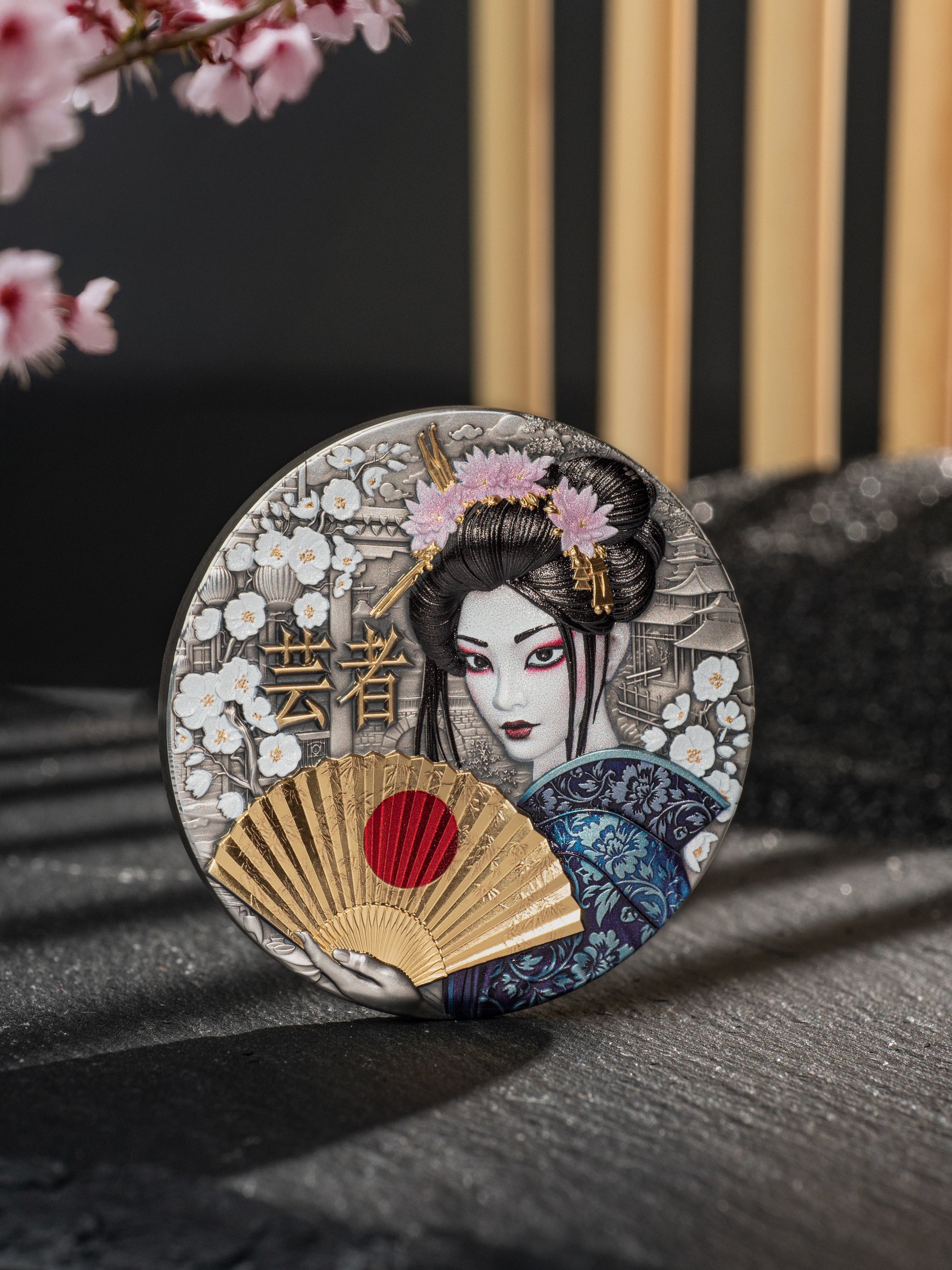 Decorative coaster with a geisha design and cherry blossoms on a dark surface.
