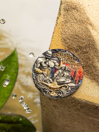 Decorative coin featuring 'Aladdin and the Wonderful Lamp' design on a textured surface with water droplets.