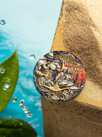 Decorative coin featuring 'Aladdin and the Wonderful Lamp' design on a stone surface with water droplets.