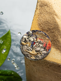 Decorative coin featuring 'Aladdin and the Wonderful Lamp' on a stone surface with water droplets.