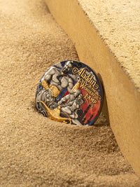 Colorful coin with Aladdin design embedded in sand
