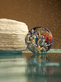 Decorative coin with Aladdin and the Magic Lamp design on a reflective surface.