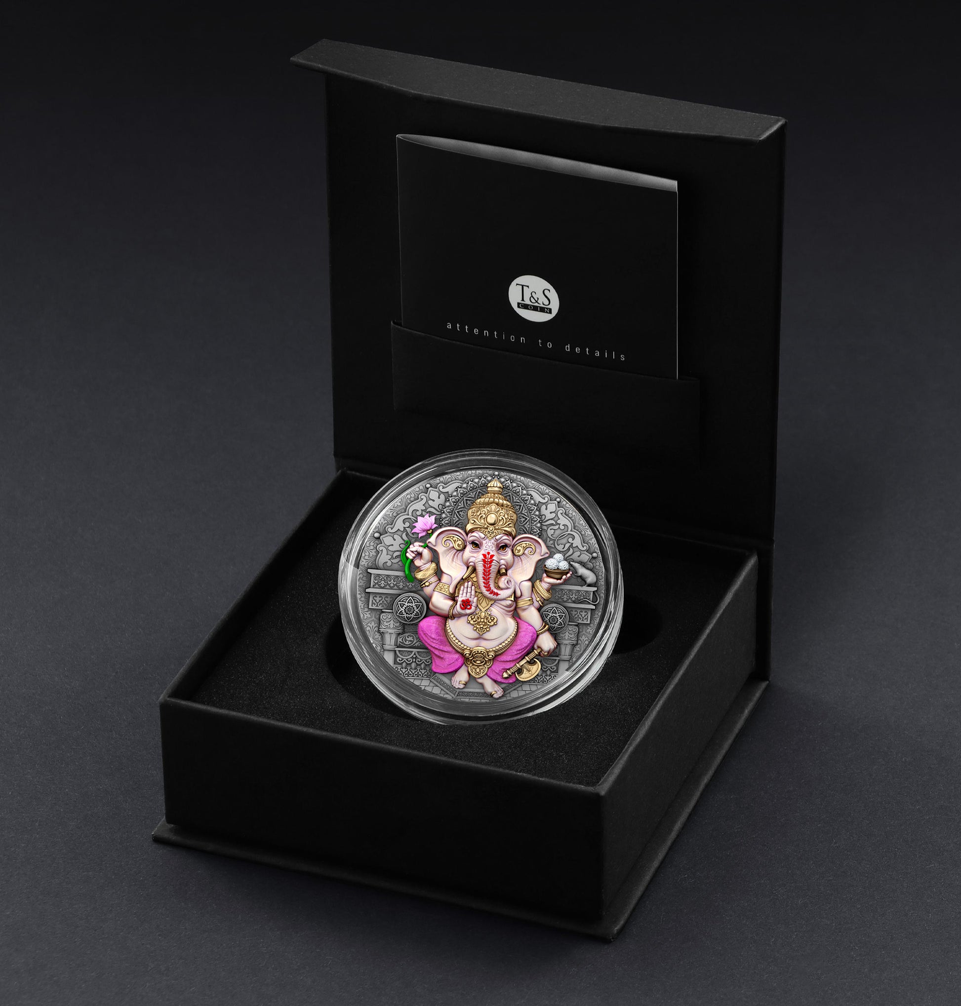 Silver coin with colorful design in a black box on a dark background