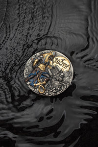 Decorative coin with intricate designs on a textured black surface