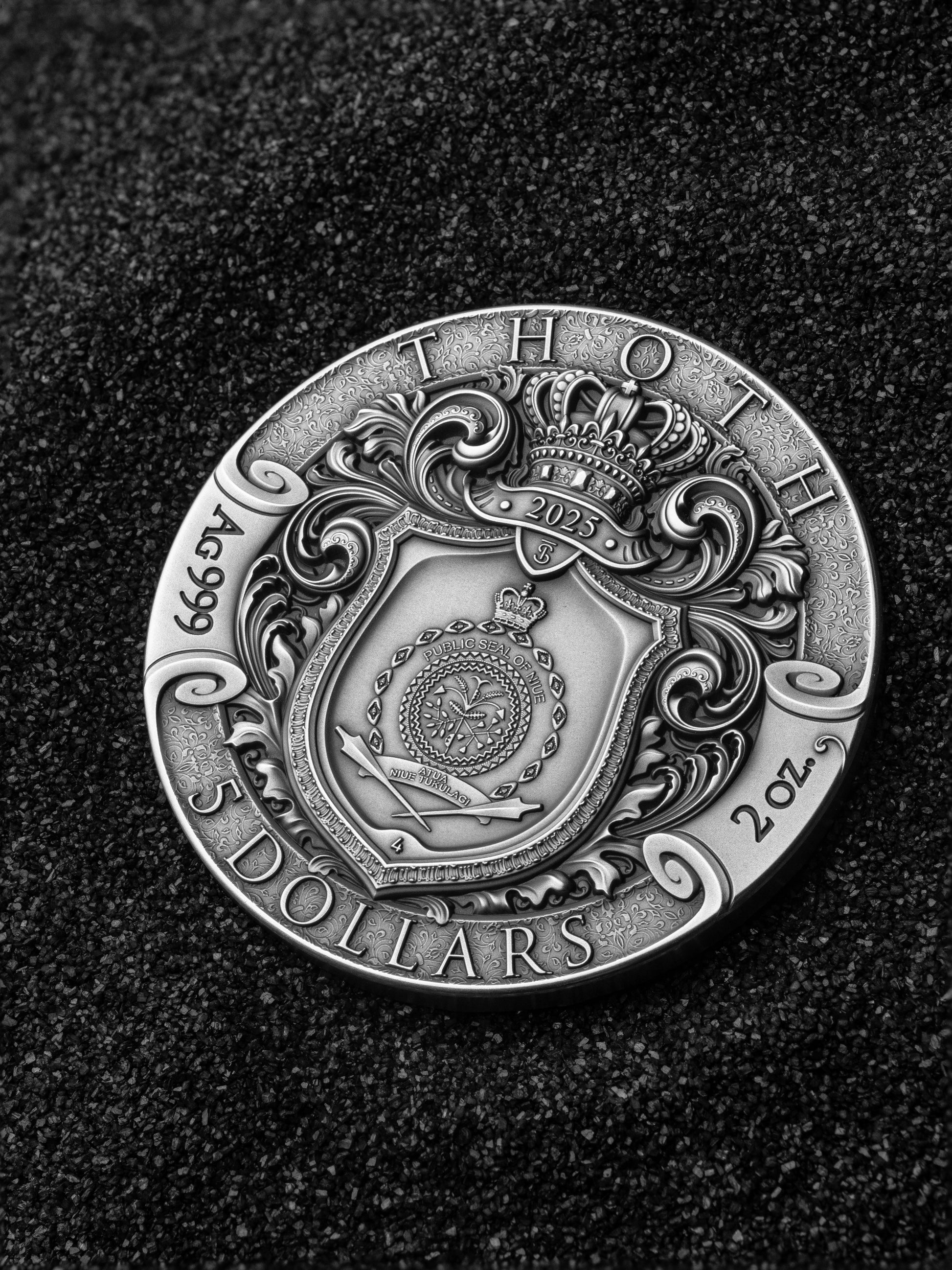 Silver coin with intricate design on a dark background