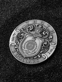Silver coin with intricate design on a dark background
